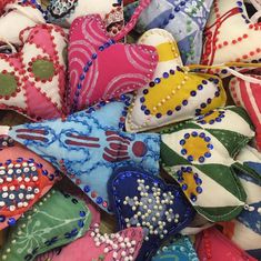 many different colored hearts are on display for sale at the market, including one with beading