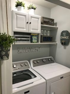 a washer and dryer in a small laundry room with white cabinets on the wall