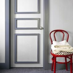 a red chair sitting next to a white door