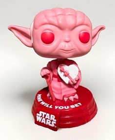 a pink star wars yoda figurine holding a heart