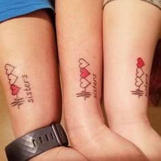 two girls with matching tattoos on their arms, one has a heart and the other has a heartbeat