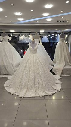 wedding gowns are displayed on mannequins in a store