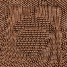 a brown knitted blanket on top of a wooden table