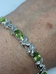 This Peridot bracelet is very lively and bright. The stones are deep colors and well matched. The sterling silver is plated with rhodium to protect the bracelet from tarnish and give the appearance of white gold. 7.5 inches My jeweler can shorten it for a $20 fee All jewelry is shipped in a nice gift box. Check out our over a THOUSAND great reviews Engraving is $4 per letter and is not always perfect depending on the piece. It can take a few days if the jeweler is busy. This is payable to Paypal Anniversary Green Sterling Silver Bracelets, Green Round Sterling Silver Bracelet, Certified Green Sterling Silver Bracelets, Formal Green Sterling Silver Bracelet, Green Oval Sterling Silver Bracelets, Green Oval Sterling Silver Bracelet, Green Gemstone Sterling Silver Bracelet, Green Gemstone Sterling Silver Round Bracelet, Oval Green Sterling Silver Bracelet