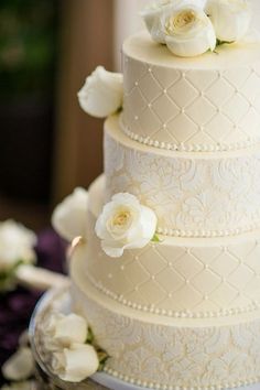 a three tiered wedding cake with white flowers on top