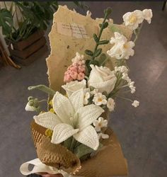 a bouquet of flowers sitting on top of a piece of paper in someone's hand