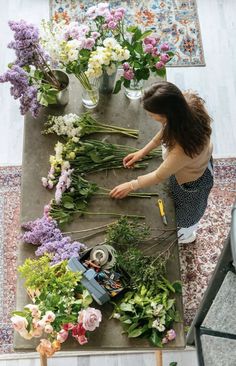 a woman is arranging flowers on a table