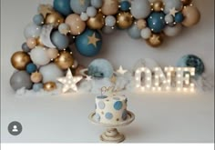 a birthday cake sitting on top of a table next to balloons and stars in the background