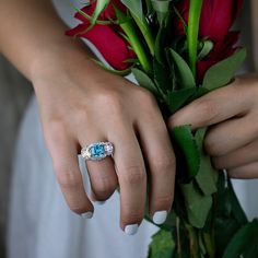 a woman's hand holding a bouquet of flowers and a ring on her finger