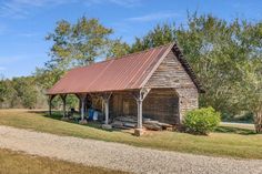 an old log cabin sits in the middle of a field