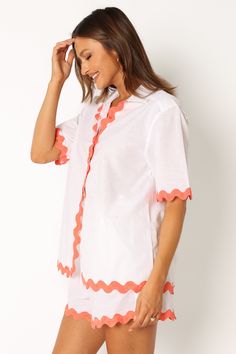 DETAILS   This season, don't forget to pack the perfect vacation-ready look. Our button down shirt is made with a v neckline and collared detail. Its short sleeves feature a vibrant melon contrast trim and hem, all while providing an oversized fit for maximum comfort.    button down shirt   v neckline  collared  short sleeves  melon contrast trim and hem  oversized fit  unlined   material - 52% cotton / 48% linen    SIZING    model is 5' 8" and wears a Size S  model stats: bust -  86  cm, waist Orange V-neck Shirt For Summer, Orange V-neck Summer Shirt, Summer Orange V-neck Shirt, White Collared Blouse For Summer, Summer Collared Tops With Contrast Trim, Collared Tops With Contrast Trim For Summer, Summer Blouse With Camp Collar And Placket, Orange Collared Summer Blouse, Summer V-neck Shirt With Placket