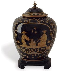 a black and gold vase sitting on top of a table