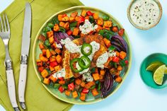 a plate with chicken, carrots and onions on it next to a bowl of ranch dressing