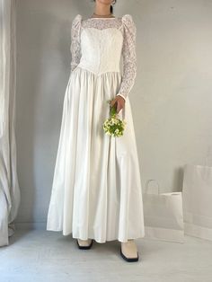 "- Vintage Laura Ashley wedding dress - 100% cotton with lace cotton nylon viscose bodice - Buttons up the back as well as up the sleeves - Removable bow at the back  - Made in Great Britain - Tagged 12 Bust: 16\" Waist: 13.5\" Length: 56\" Sleeve: 26\"" Fitted Bodice Wedding Dress With Lace Trim, Fitted Wedding Dress With Lace Trim For Bride, Bride Wedding Dress With Lace Trim And Fitted Bodice, Fitted Lace Trim Wedding Dress For Bride, Bride's Wedding Dress With Lace Trim And Fitted Bodice, Fitted Bridesmaid Gown With Lace Sleeves, Fitted Gown With Lace Sleeves For Wedding Night, Fitted Wedding Dress With Lace Sleeves For Ceremony, Fitted Wedding Dress With Lace Collar