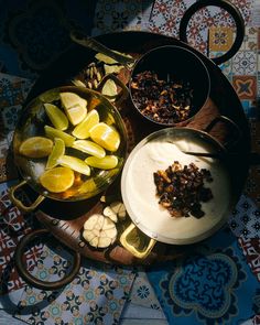 an assortment of food on a wooden platter with utensils and spoons