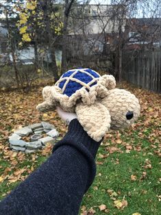 a hand is holding up a stuffed animal