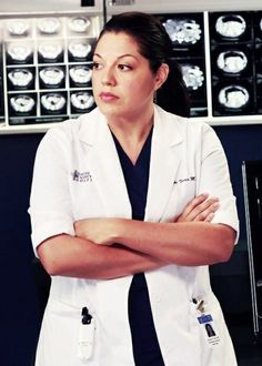 a woman in white lab coat standing with her arms crossed