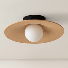 a light fixture mounted on the ceiling in a room with white walls and flooring