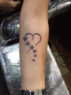 a person with a tattoo on their arm and paw prints in the shape of a heart