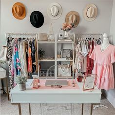 a white desk topped with lots of clothes and hats on top of it's shelves