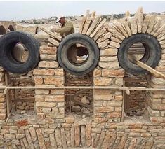 three tires stacked on top of each other in front of a wall made out of bricks