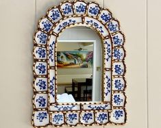 an ornate mirror hanging on the wall above a sink in a room with white walls