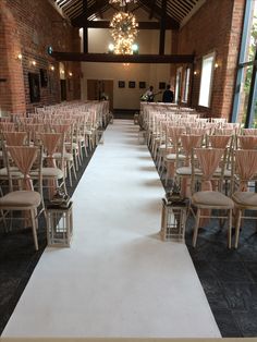 rows of chairs are lined up on the aisle for a wedding ceremony in an old brick building