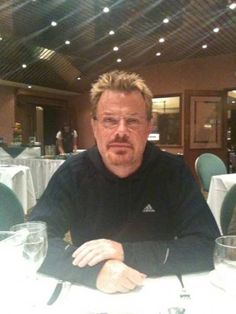 a man sitting at a table with glasses on it