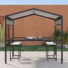 an outdoor dining table with two stools and a bench in front of a desert wall