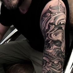 a man with a skull tattoo on his arm