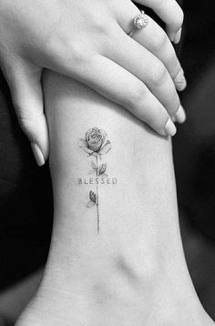 a woman's foot with a small tattoo on it that reads, blessed and a rose