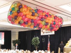 a room filled with tables and chairs covered in balloons