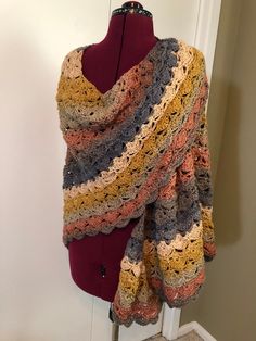 a crocheted shawl draped over a mannequin