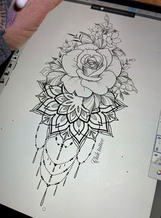 a drawing of a rose on a sheet of paper with beads and chains around it