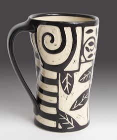 a black and white mug with designs on it