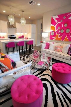 a living room filled with lots of furniture and pink accents on the walls, along with zebra print rugs