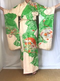 A silk Furisode Wedding Kimono in Ivory white & green. A heavier vintage Kimono that leans toward an Uchikake without the padded bottom. Shibori knotting & embroidery. Sash sold separately. M.  Fits a USA woman size M. International Express Shipping includedsee below) MATERIAL:  Textured Silk with synthetic interior. PATTERN:  Shibori & embroidered fans, flowers & tasseled cords. COLOR:  Ivory white & green with coral, lavender, steel blue, gray & metallic gold embroidery, CONDITION:  Used, vint Shibori Embroidery, Green Shibori, Vintage Long Sleeve Dress, Japanese Wedding Kimono, Robe Women's, Spots Light, Embroidery Japanese, Japanese Wedding, Wedding Kimono