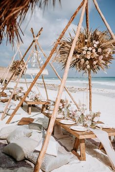 an outdoor setting on the beach with tables and chairs set up in front of it