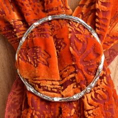 an orange and red scarf with a metal ring on it