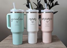 three personalized travel mugs sitting next to a potted plant