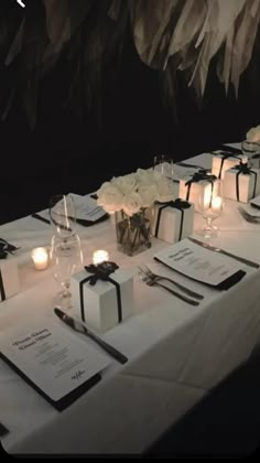 the table is set up with black and white napkins, silverware, and candles