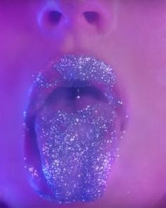 a person with their mouth open and glitter on it's tongue in front of a purple background