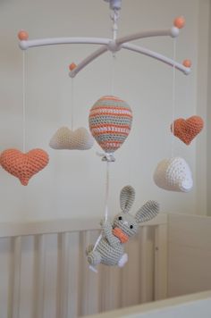 a crocheted stuffed animal hanging from a mobile in a baby's room