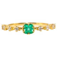 Crafted in 18 carat yellow gold, this delightful contemporary ring holds an alluring natural green emerald flanked by eight glistening round brilliant cut diamonds shimmering in unison. Her name is The Ruri Ring, the perfect ring for stacking with other beloved gems and jewels or wearing alone. The Ruri Ring Gemstone Details The bright green square emerald cut emerald is 0.31 carats and measures approximately 4.00x3.87x3.2 millimetres. The round brilliant cut diamonds total 0.20 carats and F colour and VS clarity grades. Ring Size M (Australia and UK sizing) or 6 1/4 (US and Canada) The Ruri Ring can be resized prior to shipping upon request. Resizing is complimentary up or down three sizes or please message us for a quote if more sizes are needed. Great to Know The Ruri Ring belongs to ou Yellow Gold Emerald-cut Ring With Single Cut Diamonds, Luxury Green Emerald Ring With Rose Cut Diamonds, Green Emerald Ring With Single Cut Diamonds For Promise, Emerald Green Promise Ring With Single Cut Diamonds, Green Emerald Cut Diamond Ring With Rose Cut Diamonds, Classic Green Emerald Ring With Single Cut Diamonds, Luxury Green Emerald Ring With Single Cut Diamonds, Classic Green Diamond Ring With Single Cut Diamonds, Green Diamond Ring With Single Cut Emerald Shape