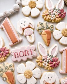 some decorated cookies are on a table with flowers and bunnies in the shape of numbers