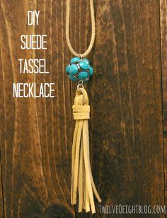 a blue beaded tassel necklace hanging on a wooden background with the words diy suede tassel necklace