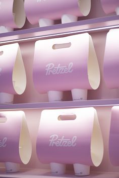 two rows of pastel pink and white paper dispensers with the word fettrez on them