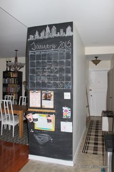 a chalkboard with calendars on it is in the entry way of a house