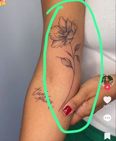 a woman's arm with a flower tattoo on it