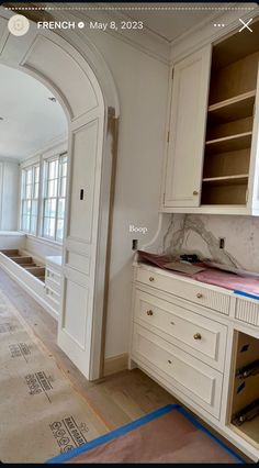 an empty kitchen with white cabinets and marble counter tops in the process of remodeling